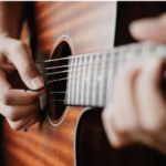 Picking guitar strings on an acoustic guitar