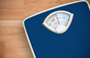 Blue weight scale on a wooden floor.