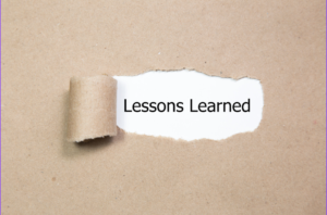 A tan piece of paper with a section peeled back and the words Lessons Learned shown underneath.