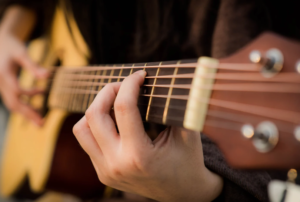 Fingerstyle picking an acoustic guitar.