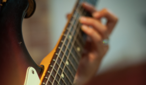 Forming a barre chord on an electric guitar.